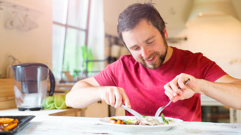 a fit man is eating mindfully by testing the food
